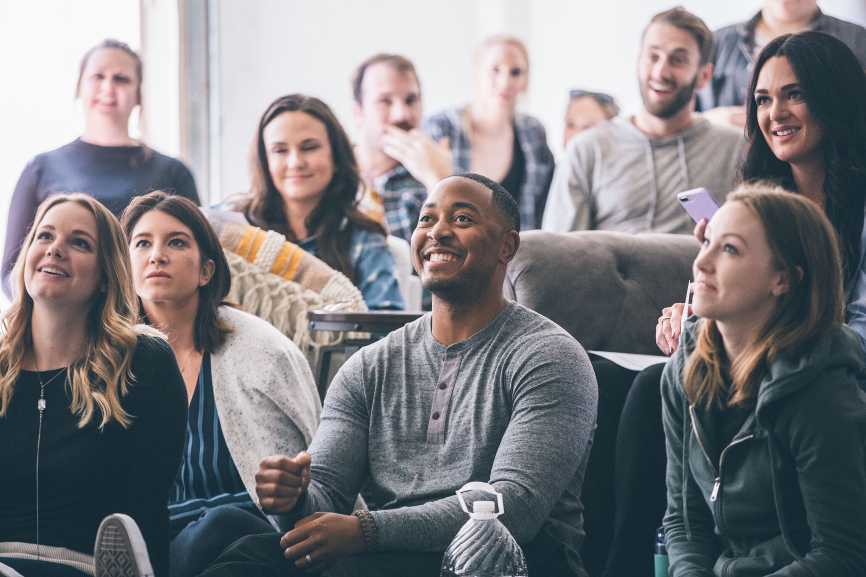 Group of people smiling and listening to presentation