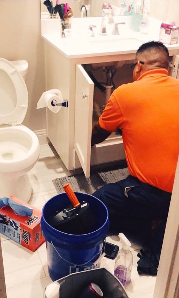 man repairs bathroom sink