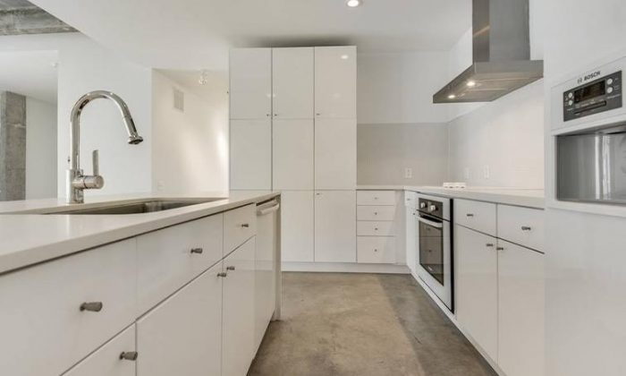 apartment kitchen with concrete floors and white finishes