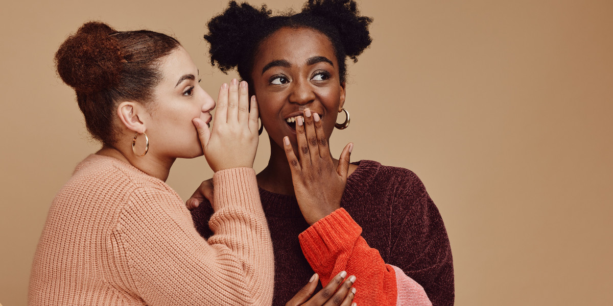 two girls telling a secret