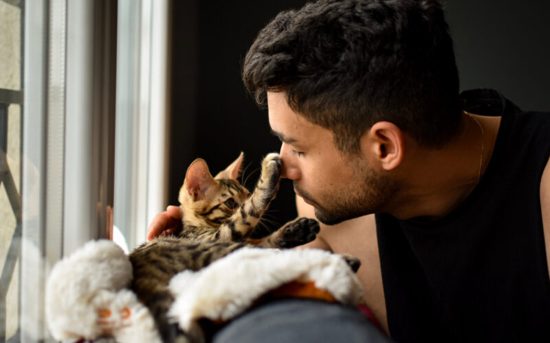 man snuggling with cat