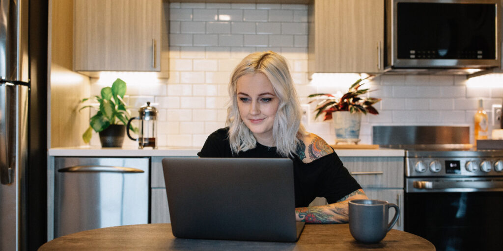 A panoramic view of a city skyline at dusk, showcasing a mix of modern skyscrapers and historic buildings. The scene is illuminated by city lights, with a river in the foreground reflecting the colors of the sunset. The sky transitions from deep blue to warm hues of orange and pink, creating a serene atmosphere. Notable architectural features include tall buildings with distinctive designs, including a structure with spires. The overall ambiance suggests a vibrant urban setting.