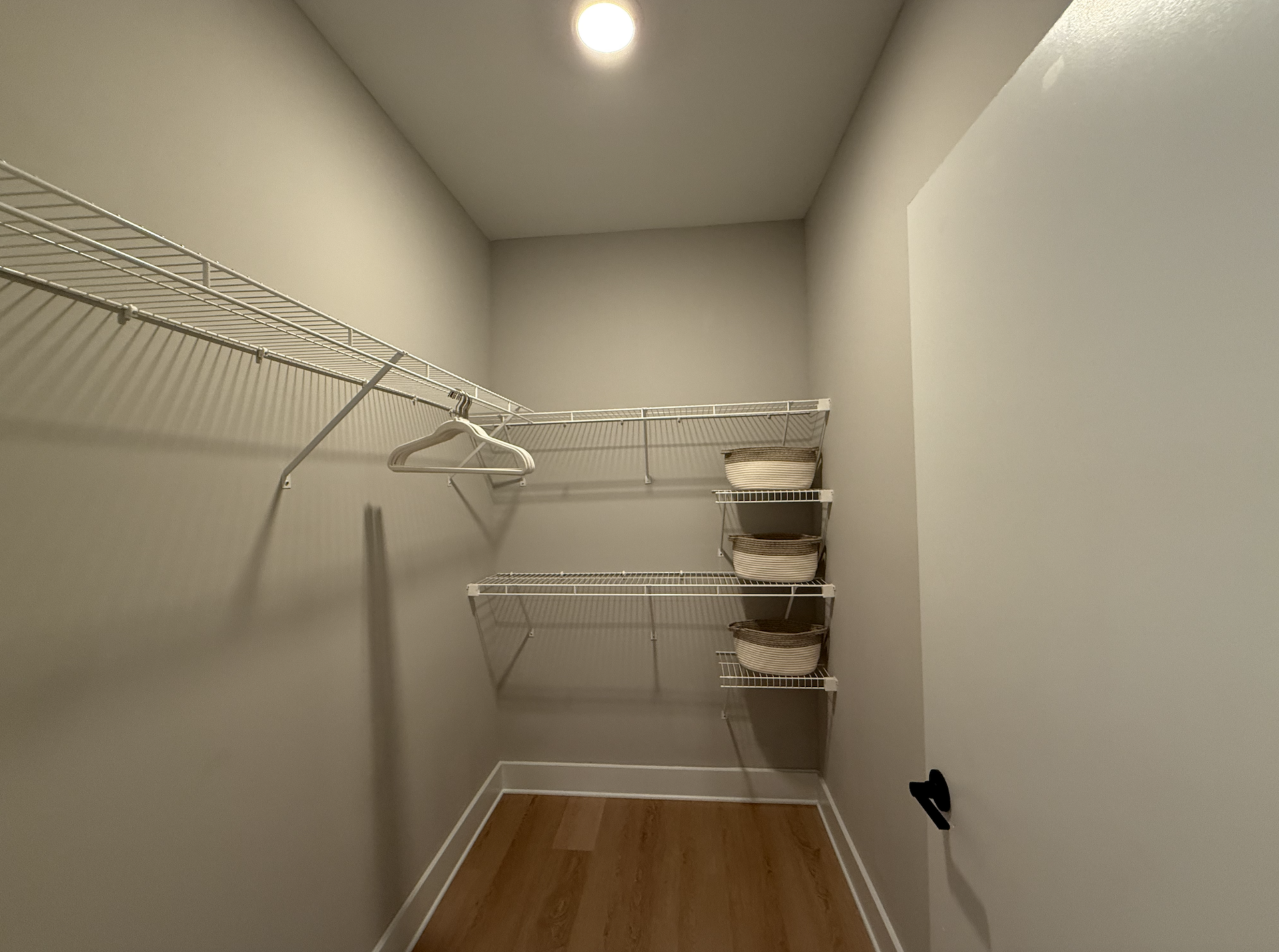 Apartment walk in closet in Germantown with built in shelving.