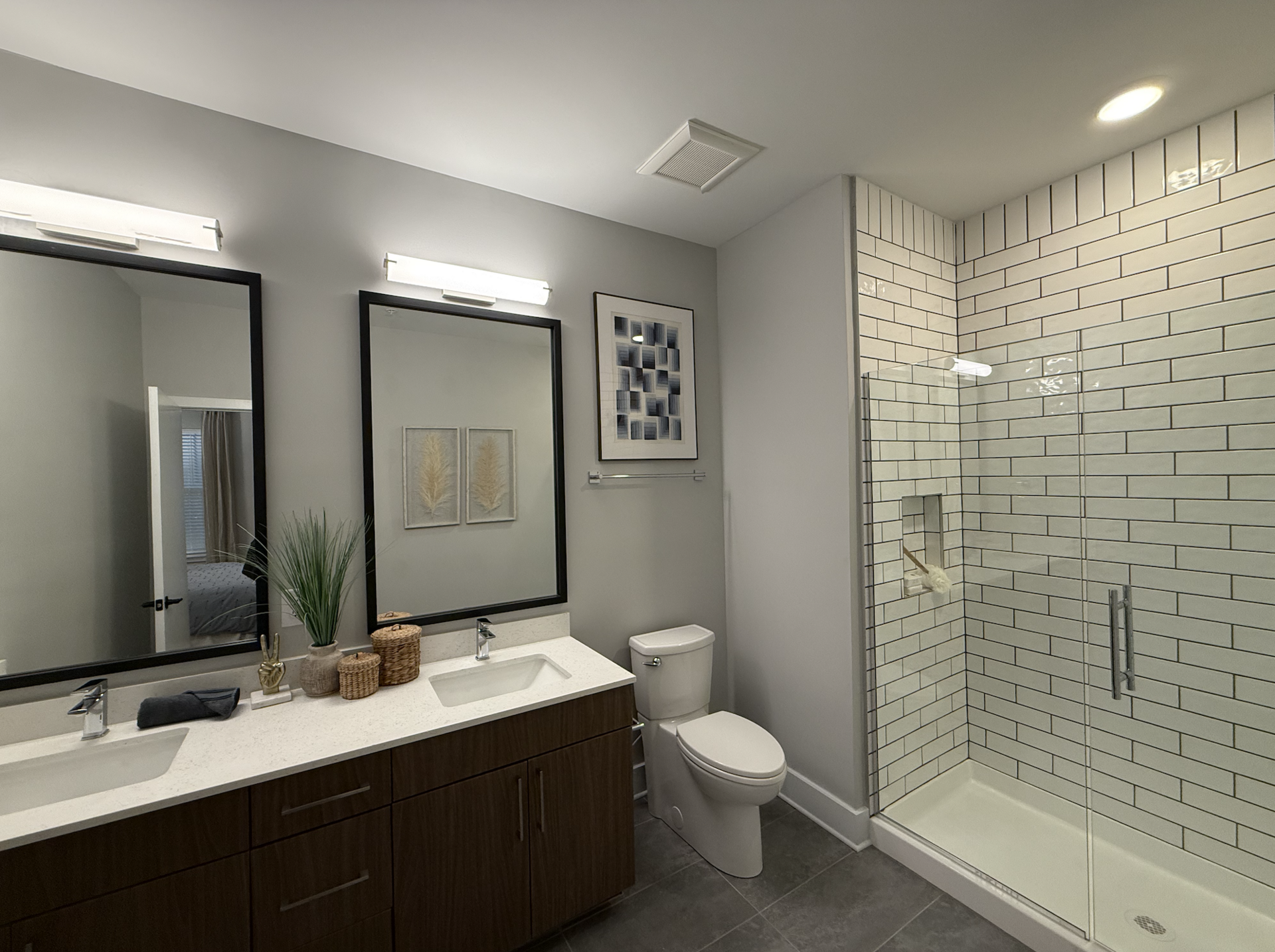 Germantown apartment bathroom with dual vanity sinks and a walk in shower.