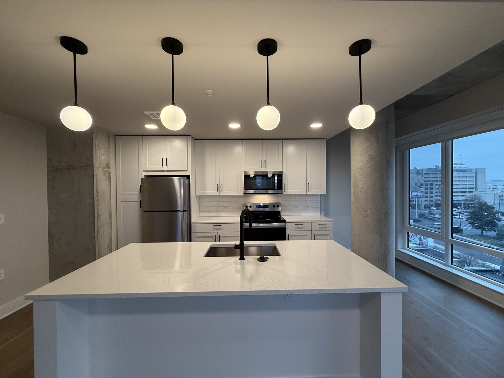 Nashville Midtown apartment kitchen with white finishes and a large island.