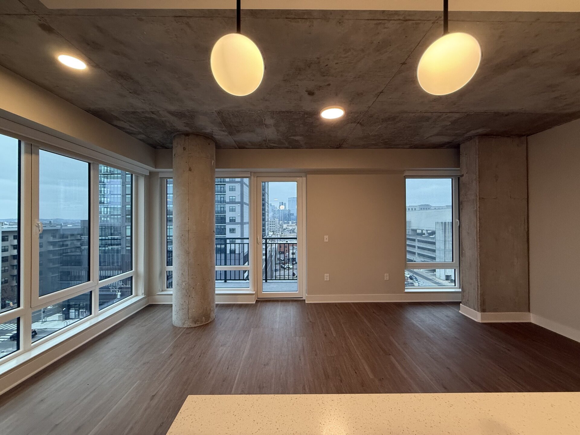 Nashville Midtown apartment living room with floor to ceiling windows and concrete pillars.