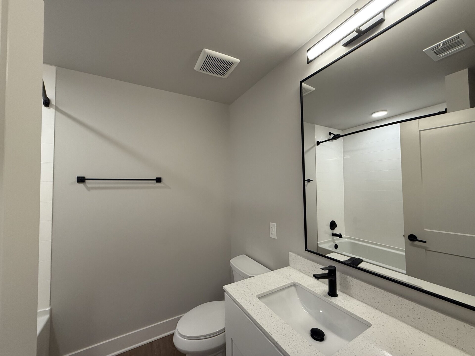 Nashville Midtown apartment bathroom with black hardware and a tub.