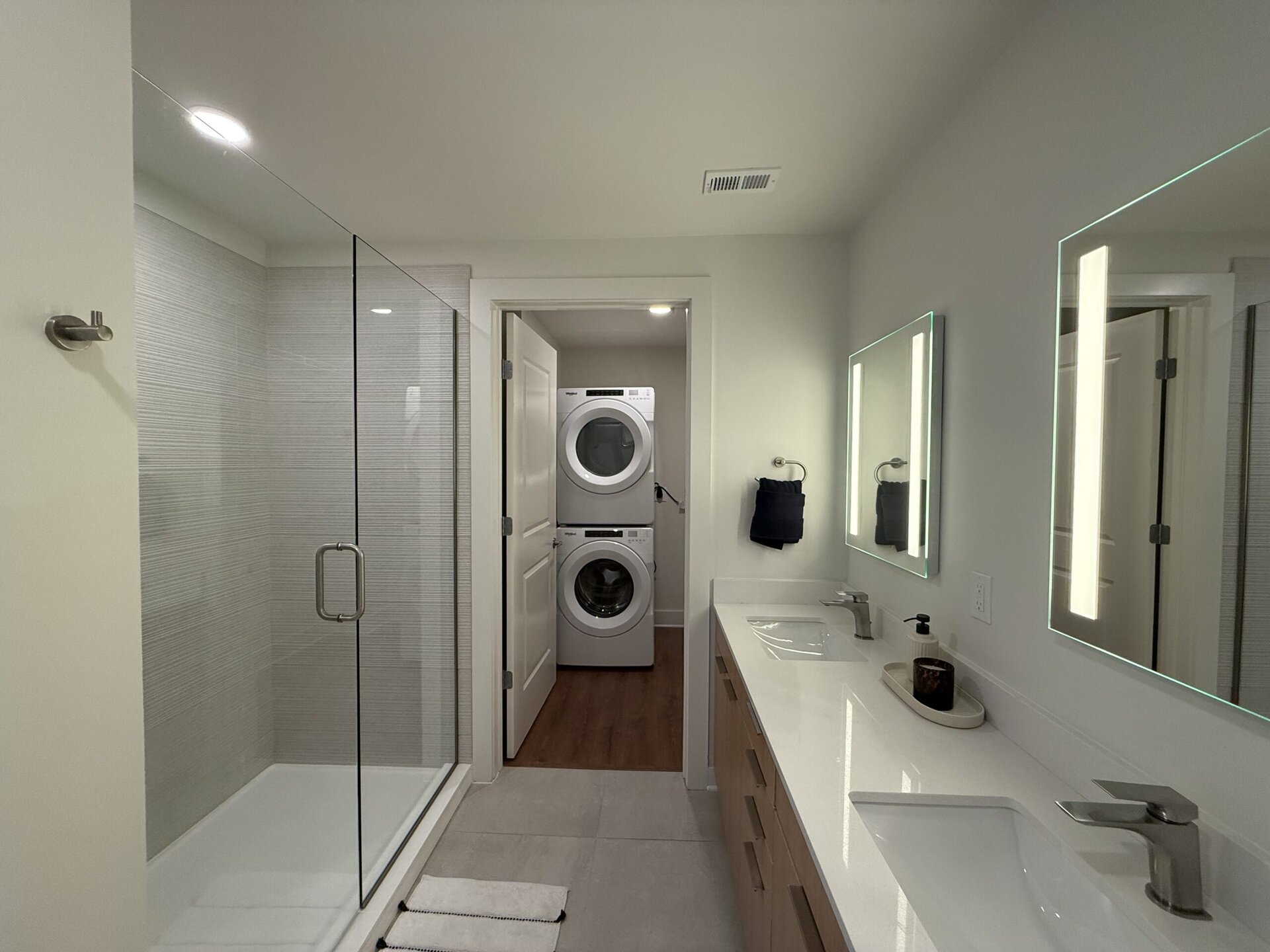 Germantown apartment bathroom with dual vanity sinks and a large walk in shower.