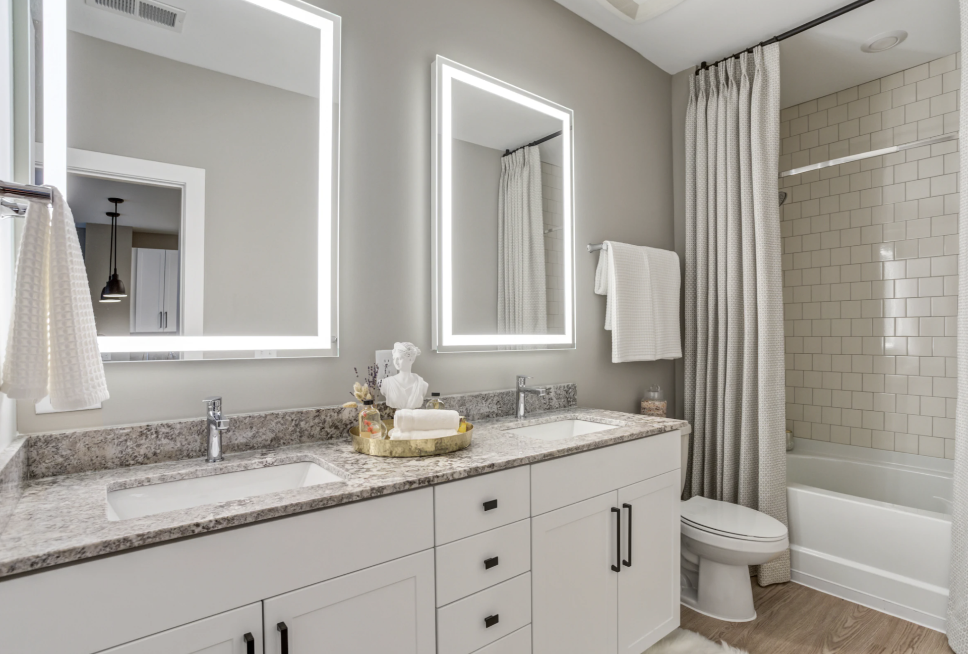 Nashville Midtown apartment bathroom with dual vanity sinks and LED mirrors.