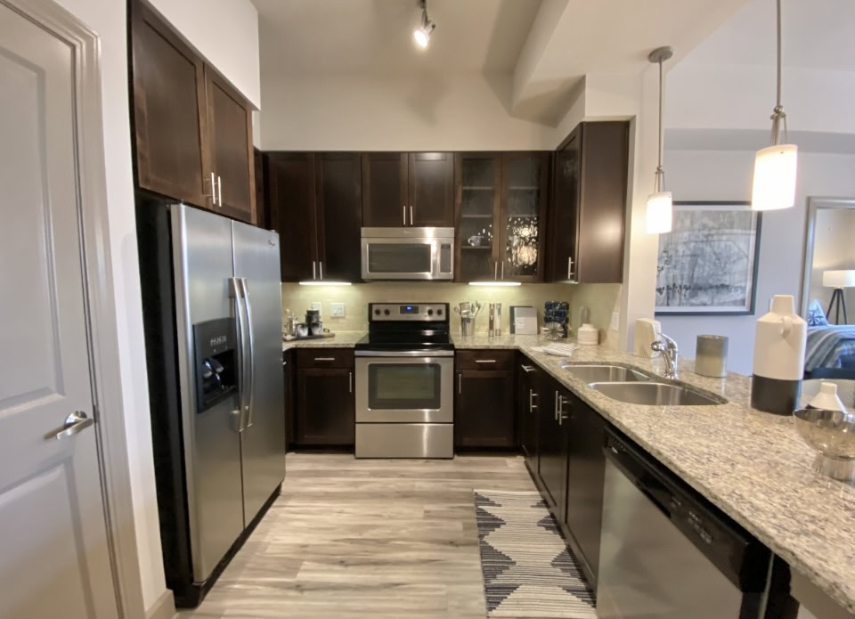 Buckhead apartment kitchen with dark wood cabinets.