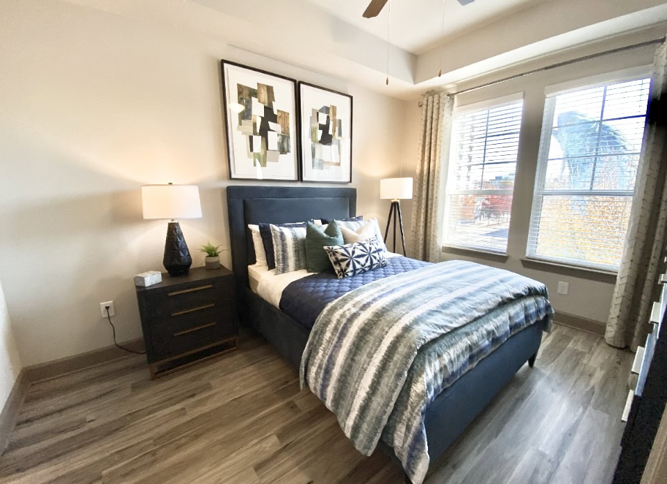 Buckhead apartment bedroom with all wood flooring and big windows.