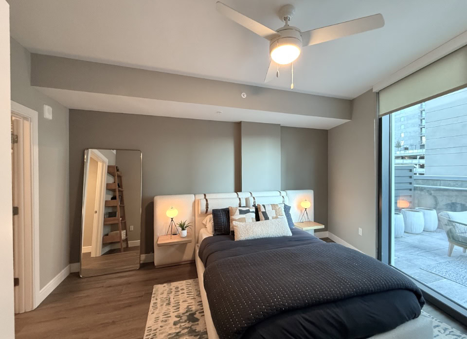 Downtown Nashville apartment bedroom with floor to ceiling windows.