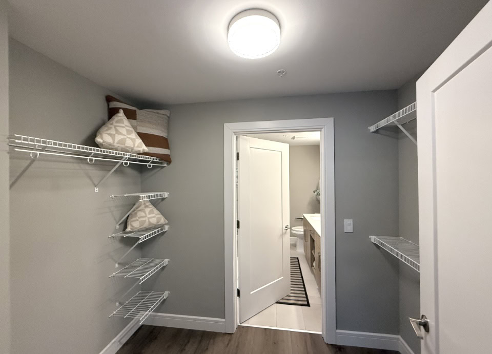 Downtown Nashville apartment large walk in closet with wire organization racks.