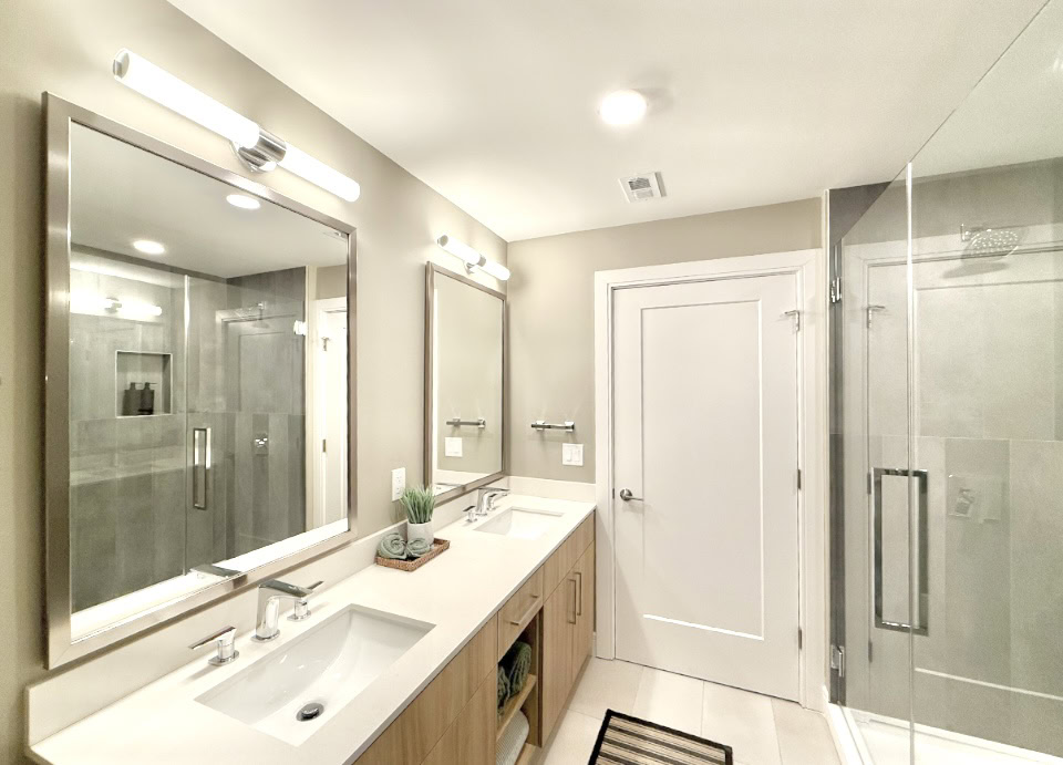 Downtown Nashville apartment bathroom with double vanities and a large walk in shower.