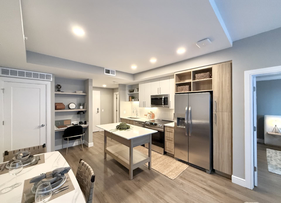Downtown Nashville apartment kitchen with two toned cabinets, a built in desk area, and stainless steel appliances.