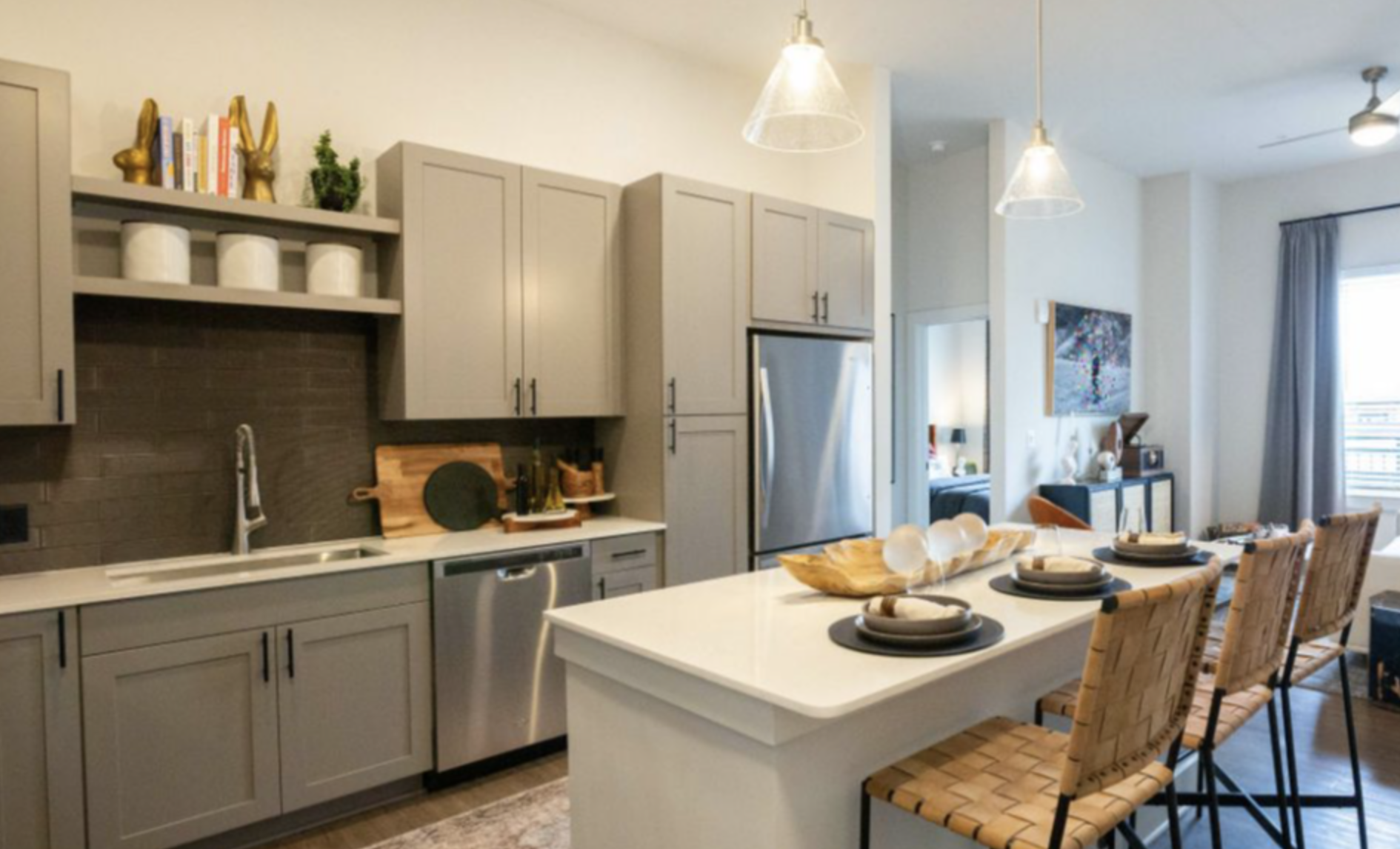 Decatur apartment kitchen with an island, grey cabinets, and stainless steel appliances.