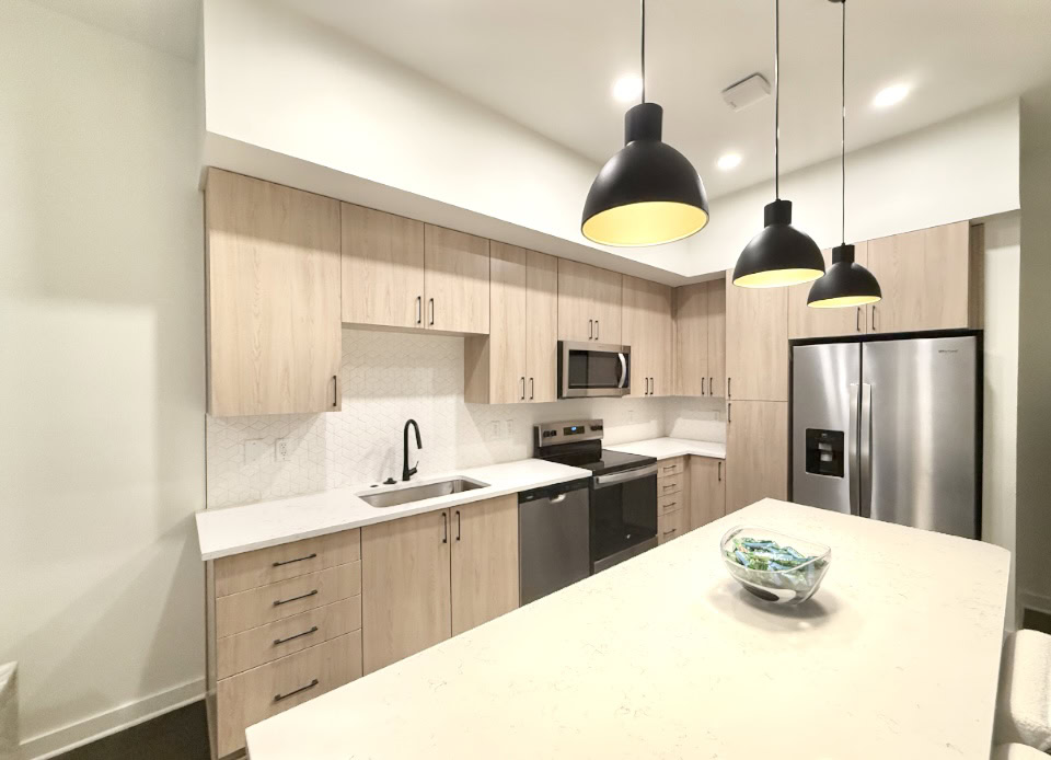 Germantown apartment kitchen with light wood cabinetry and black, modern finishes.