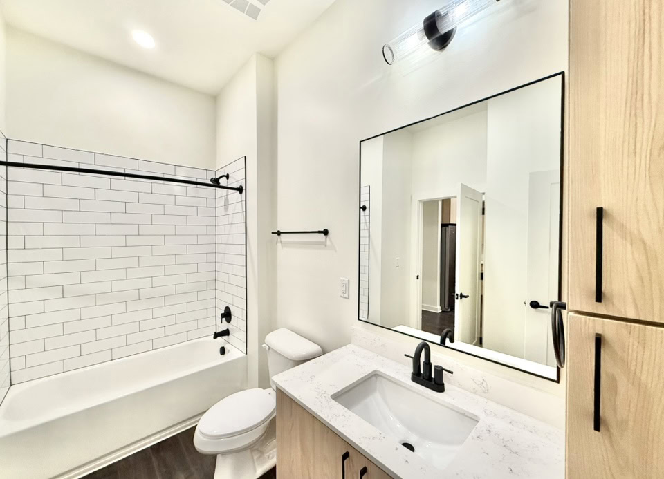 Germantown apartment bathroom with a large mirror and bath tub.