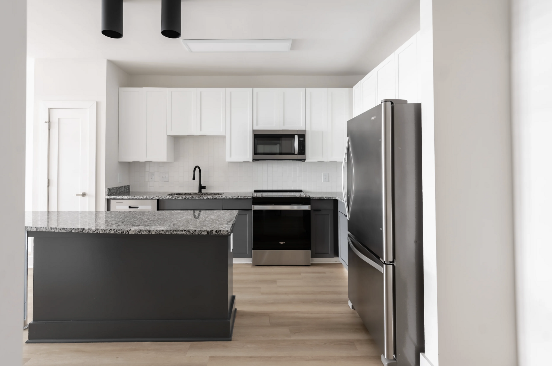 West Midtown Apartment kitchen with two toned cabinets and a large kitchen island.