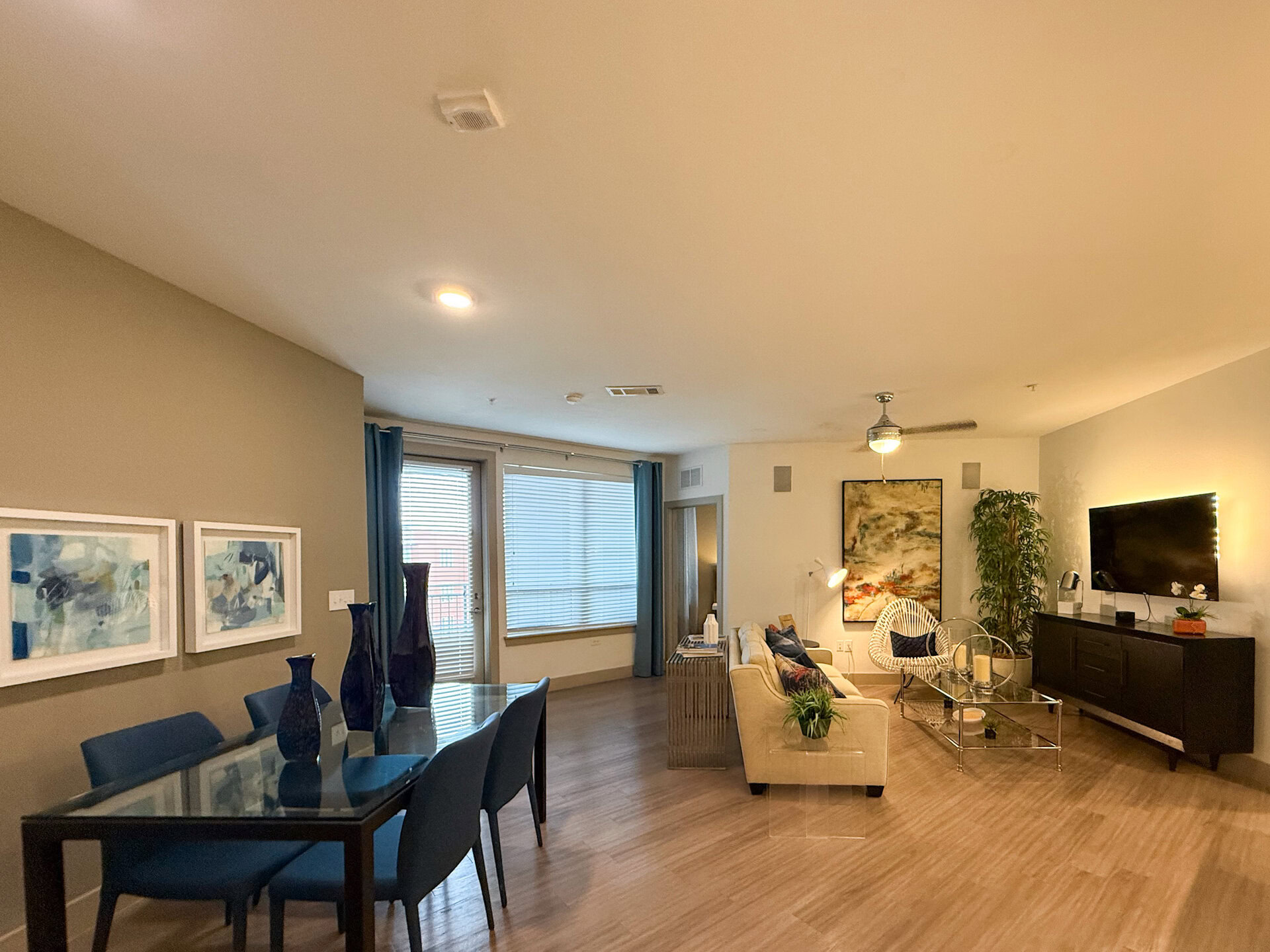 A modern living space featuring a dining area. The flooring is wooden, contributing to a warm ambiance.
