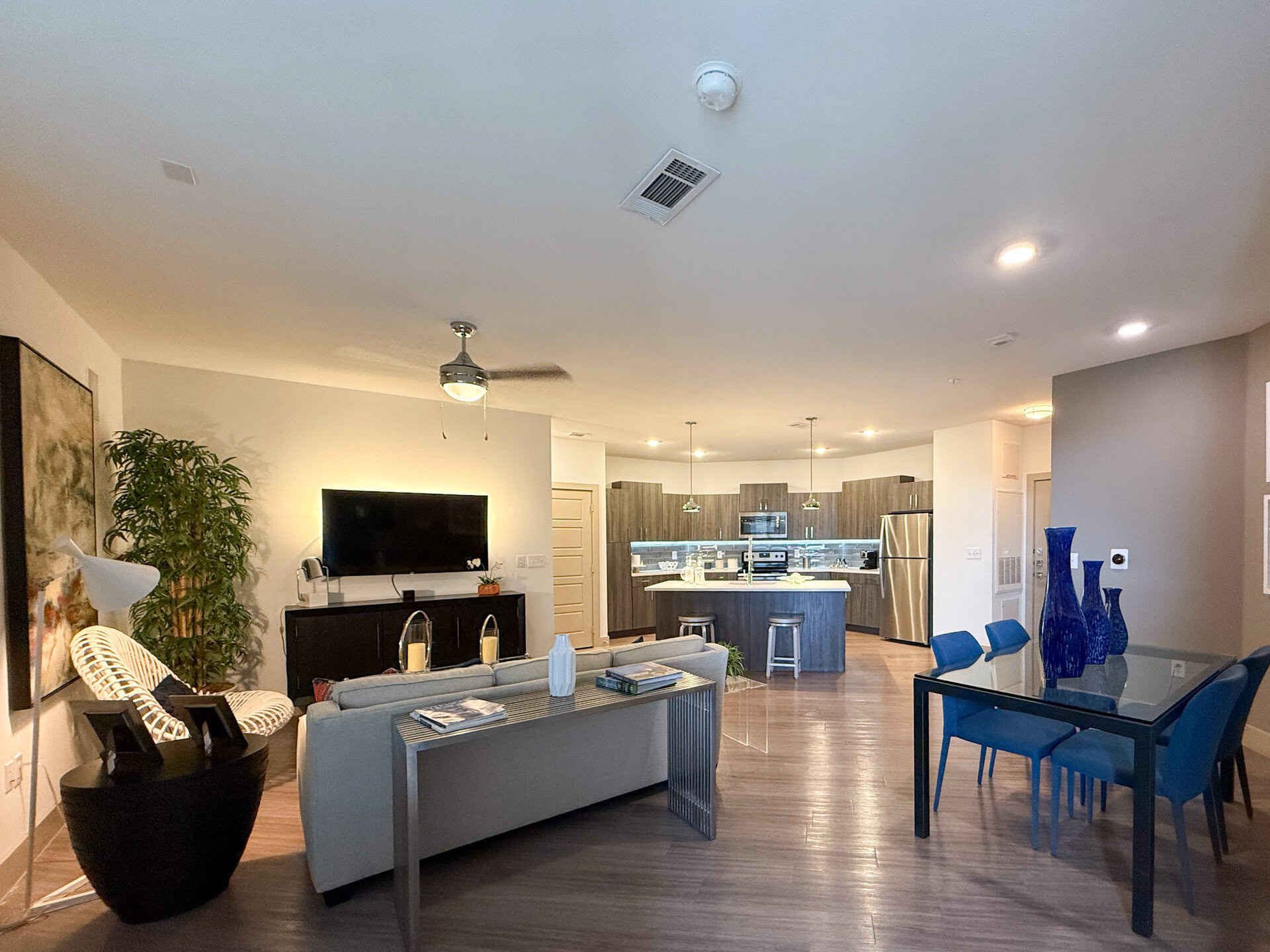 San Antonio modern luxe apartment featuring the living room & dining room, with the kitchen in the center.