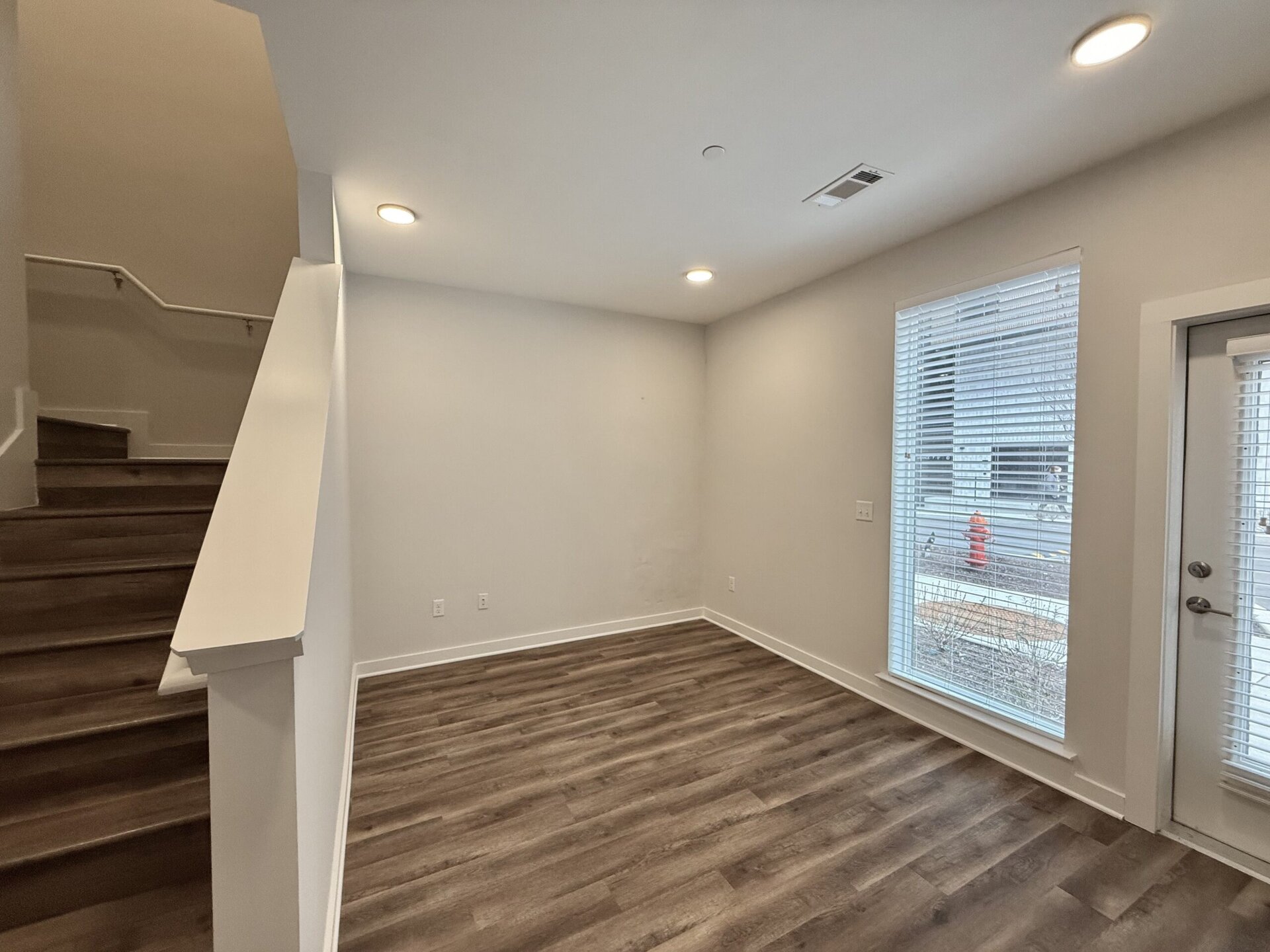 Apartments in Downtown Nashville, living room with big windows and a staircase.