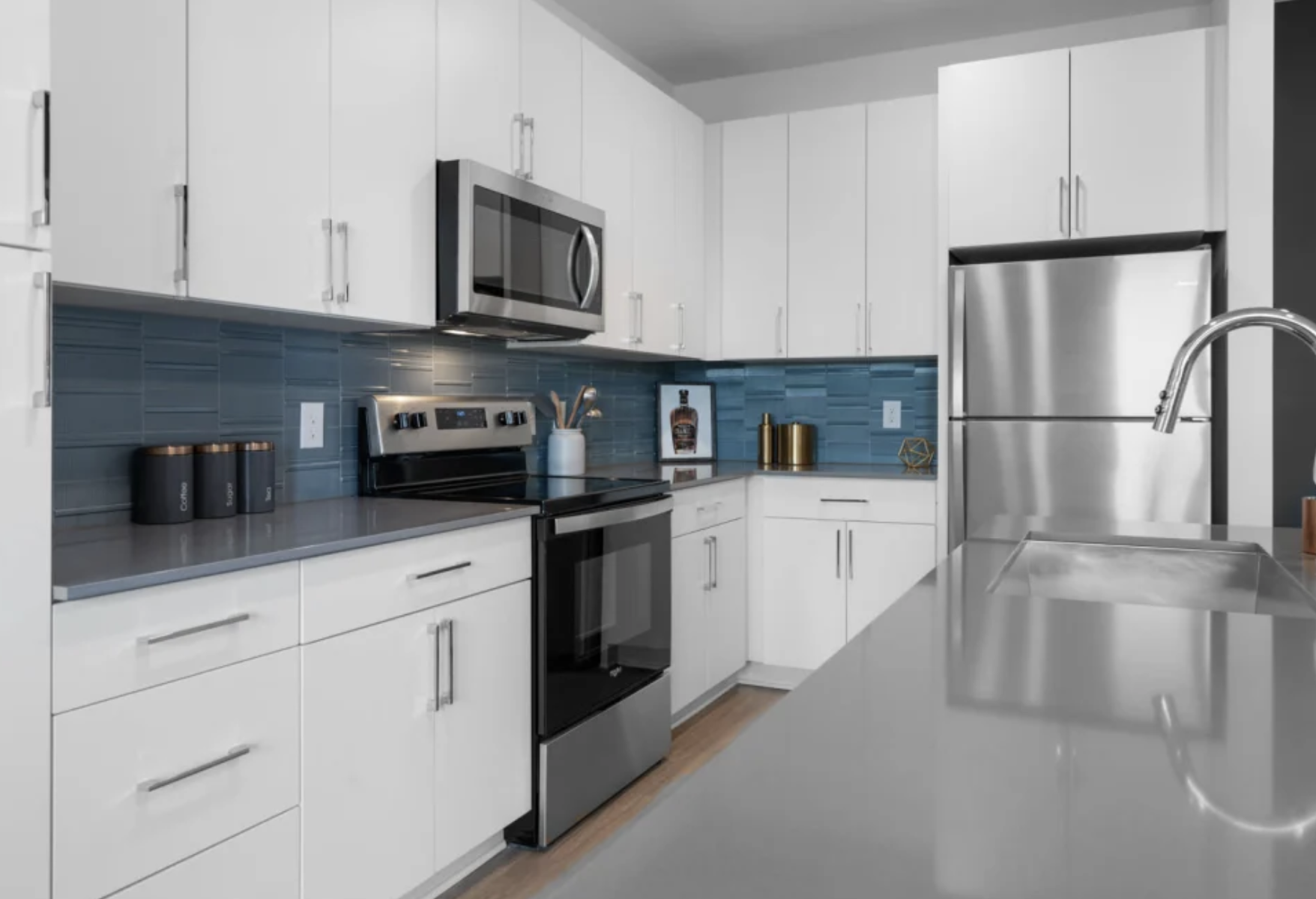Apartments in Grant Park, kitchen with white cabinetry and blue tiles.