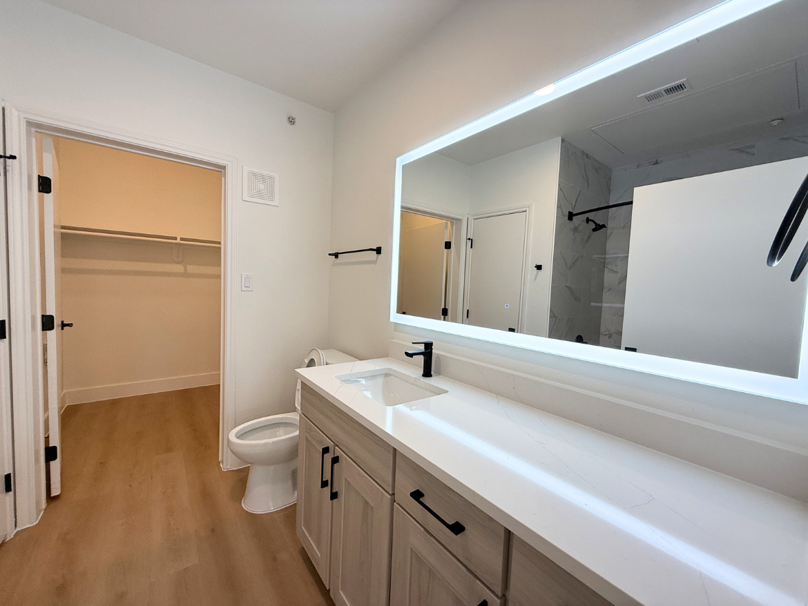 The Colony apartment bathroom with spacious vanity and tub shower