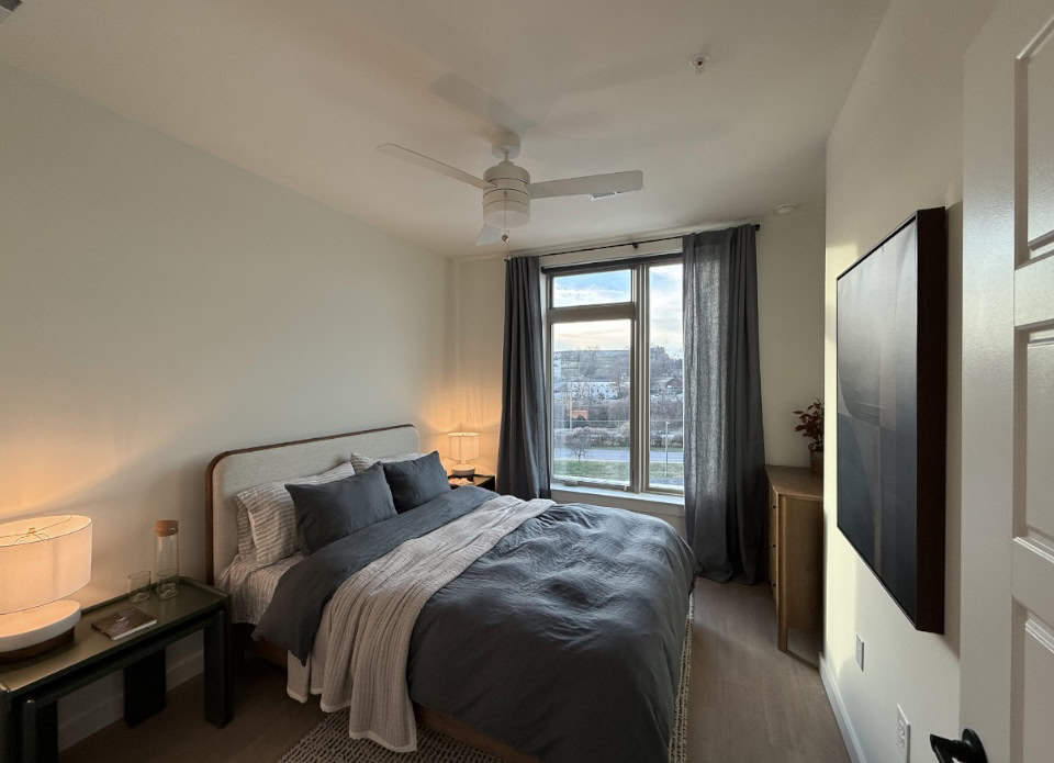 Nashville Apartment bedroom with floor to ceiling windows and tall ceilings.