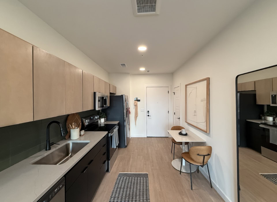 Nashville Apartment kitchen with two toned cabinets and an olive green backsplash.