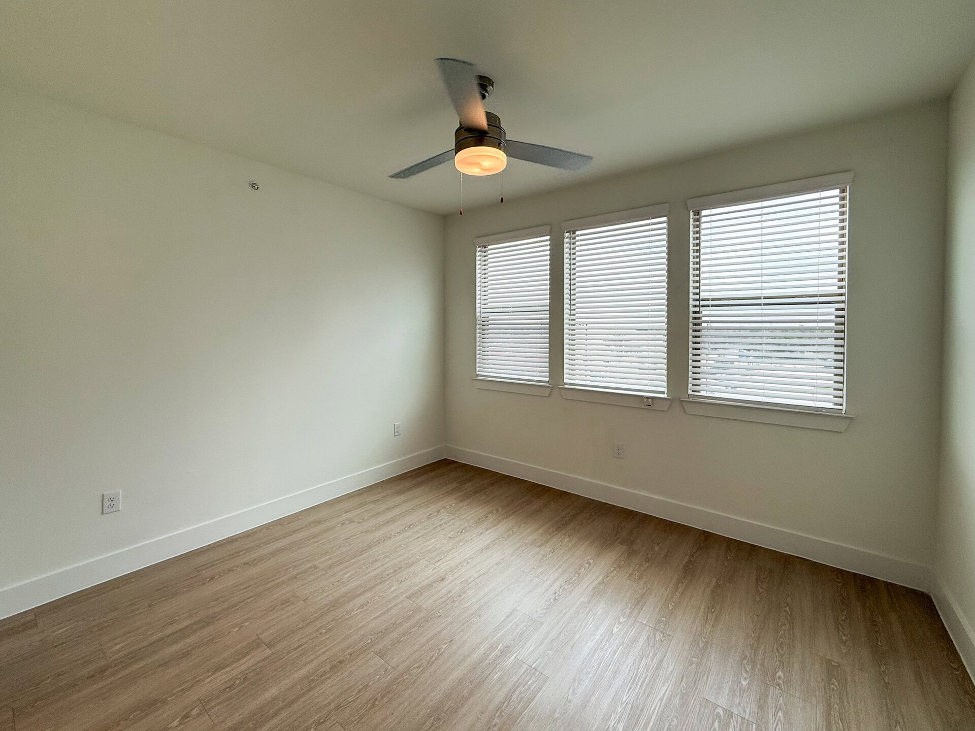 A bright, spacious primary bedroom, the San Antonio apartment bedroom features three windows that allow natural light to enter.