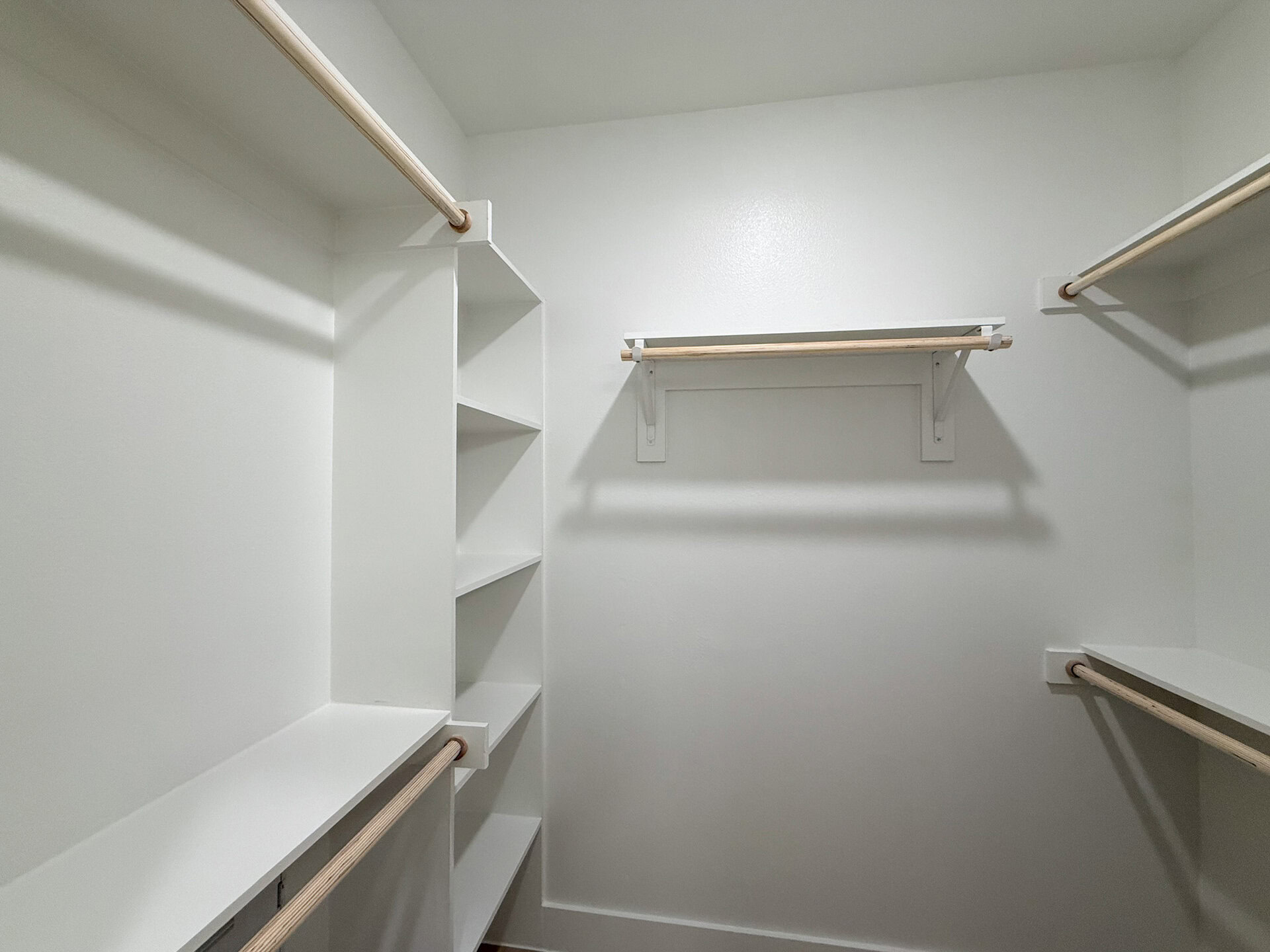 A modern San Antonio apartment closet with shelves and racks to hang clothes