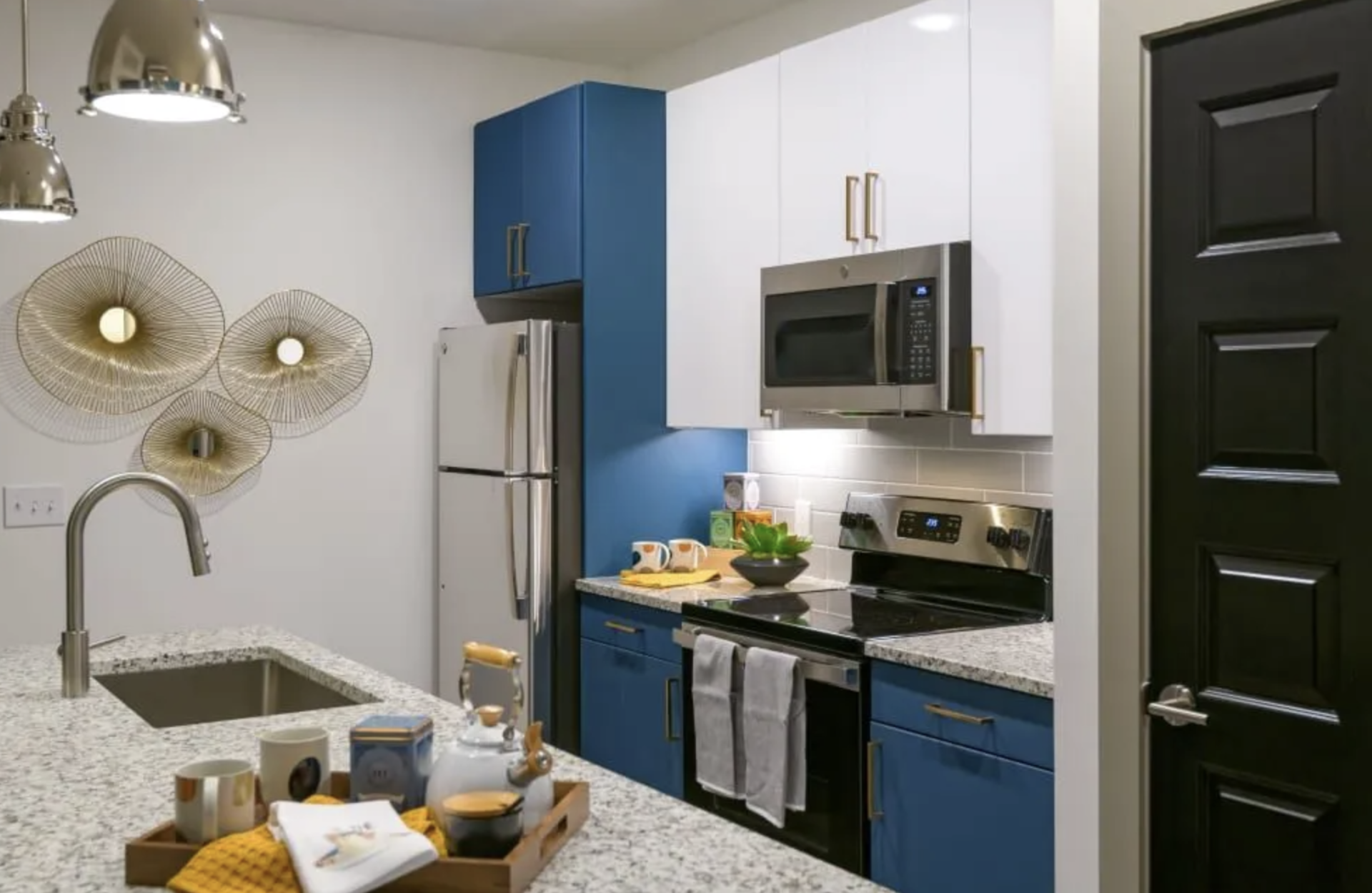 Atlanta Apartment kitchen with blue and white cabinets and stainless steel appliances.
