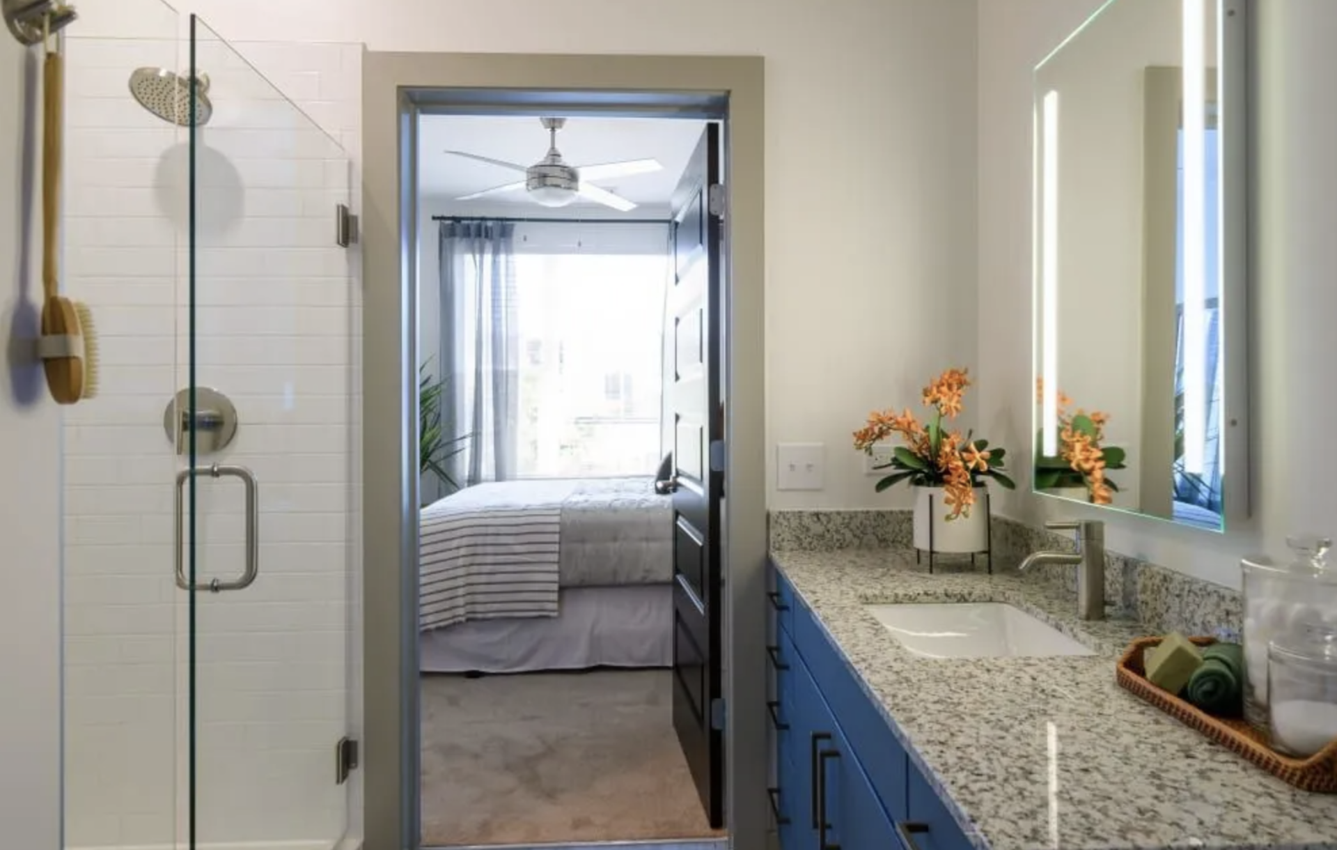 Atlanta Apartment bathroom with blue cabinets and a walk-in shower.