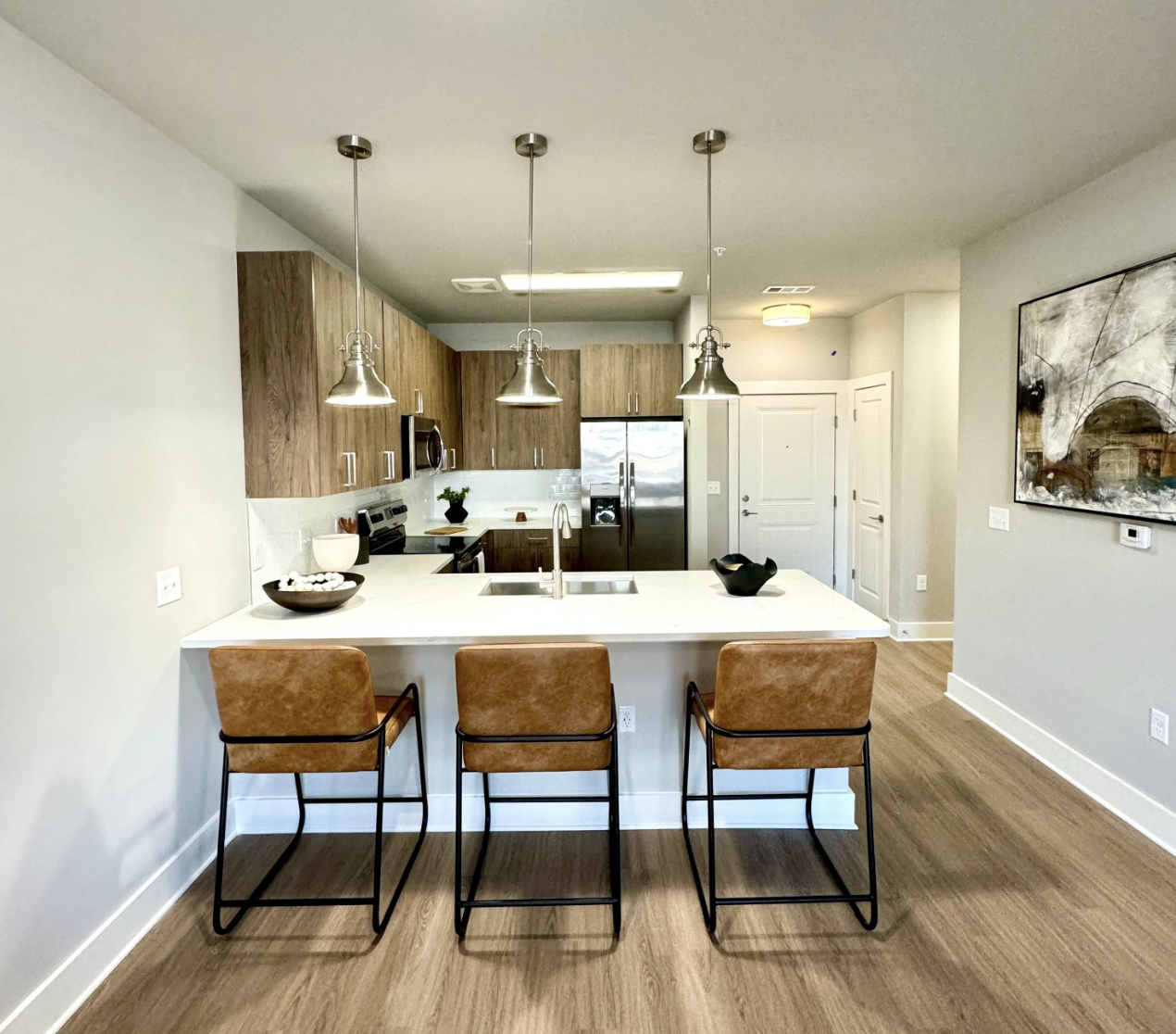 Atlanta Apartment kitchen with brown cabinets, an L-shaped kitchen, and stainless steel appliances.