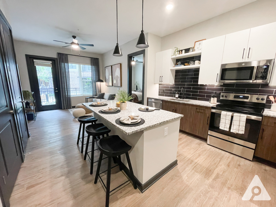 Atlanta Apartment kitchen with two toned cabinets, dark finishes, and tons of space.