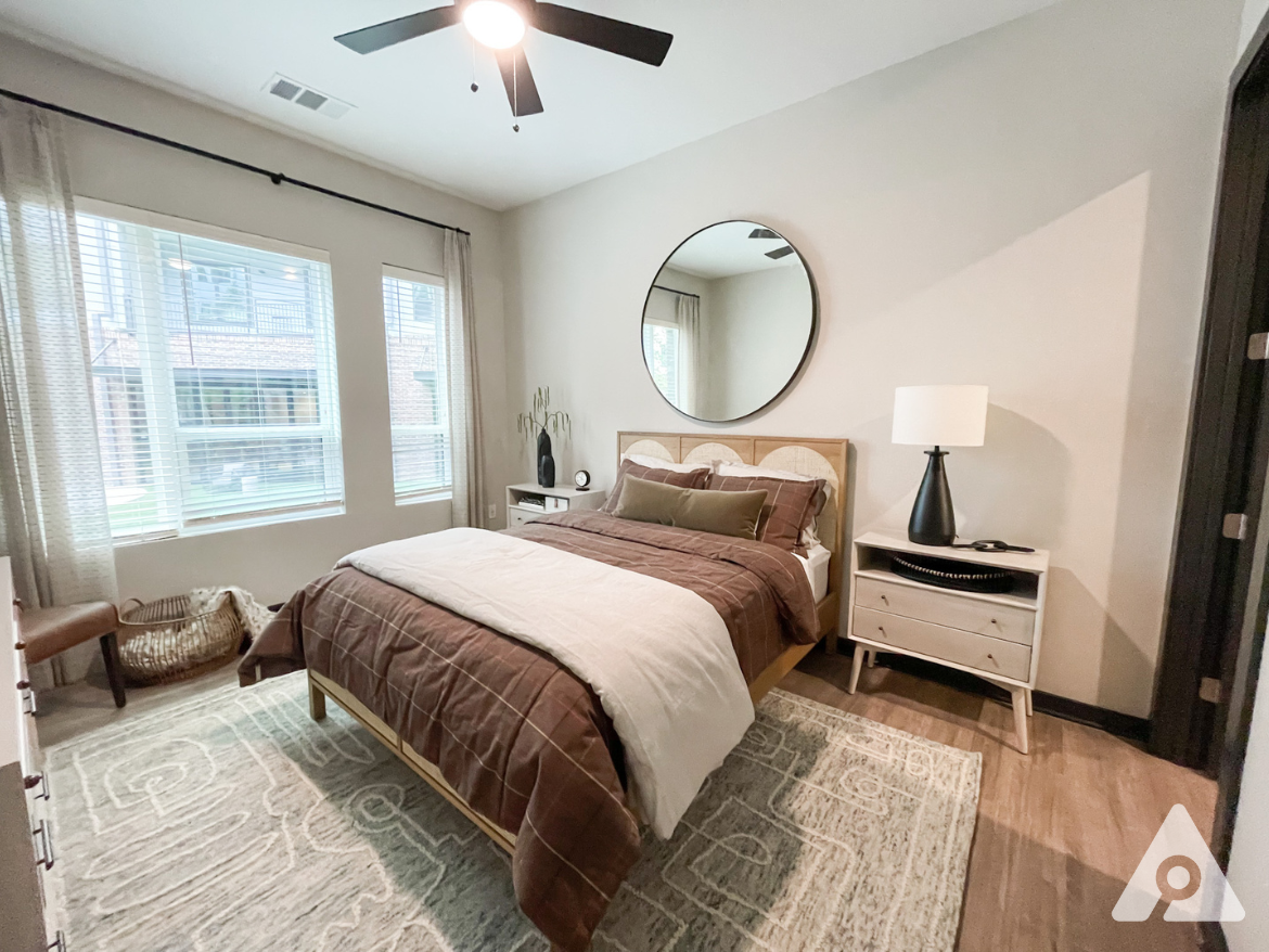 Atlanta Apartment bedroom with wood flooring and a large window.