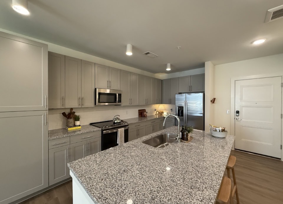 Nashville Apartment kitchen with gray cabinets and a large kitchen island.