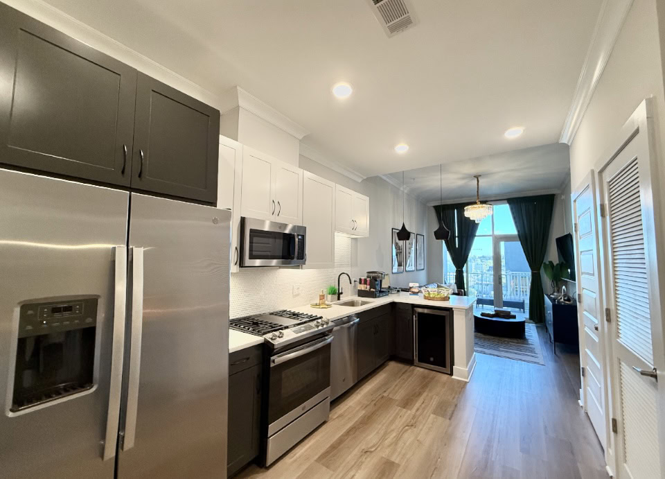 Nashville Apartment kitchen with two tones cabinets, a gas stove, and a mini wine fridge.