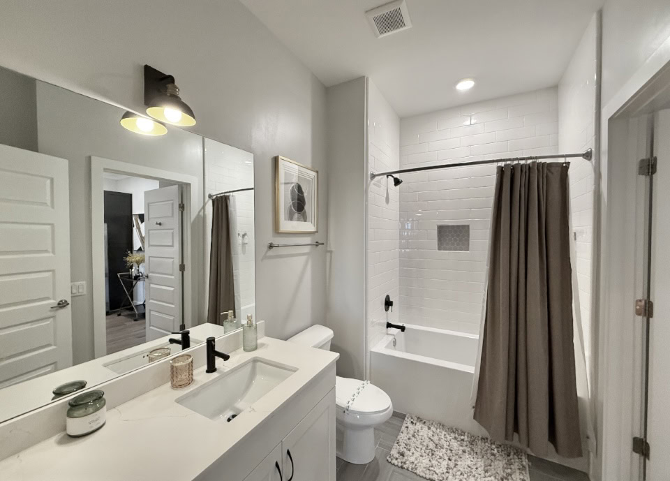 Nashville Apartment bathroom with white cabinets and a bath tub.