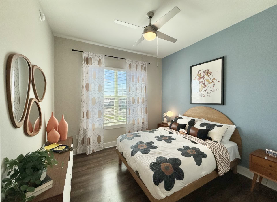 Atlanta Apartment bedroom with wood flooring and a large window.
