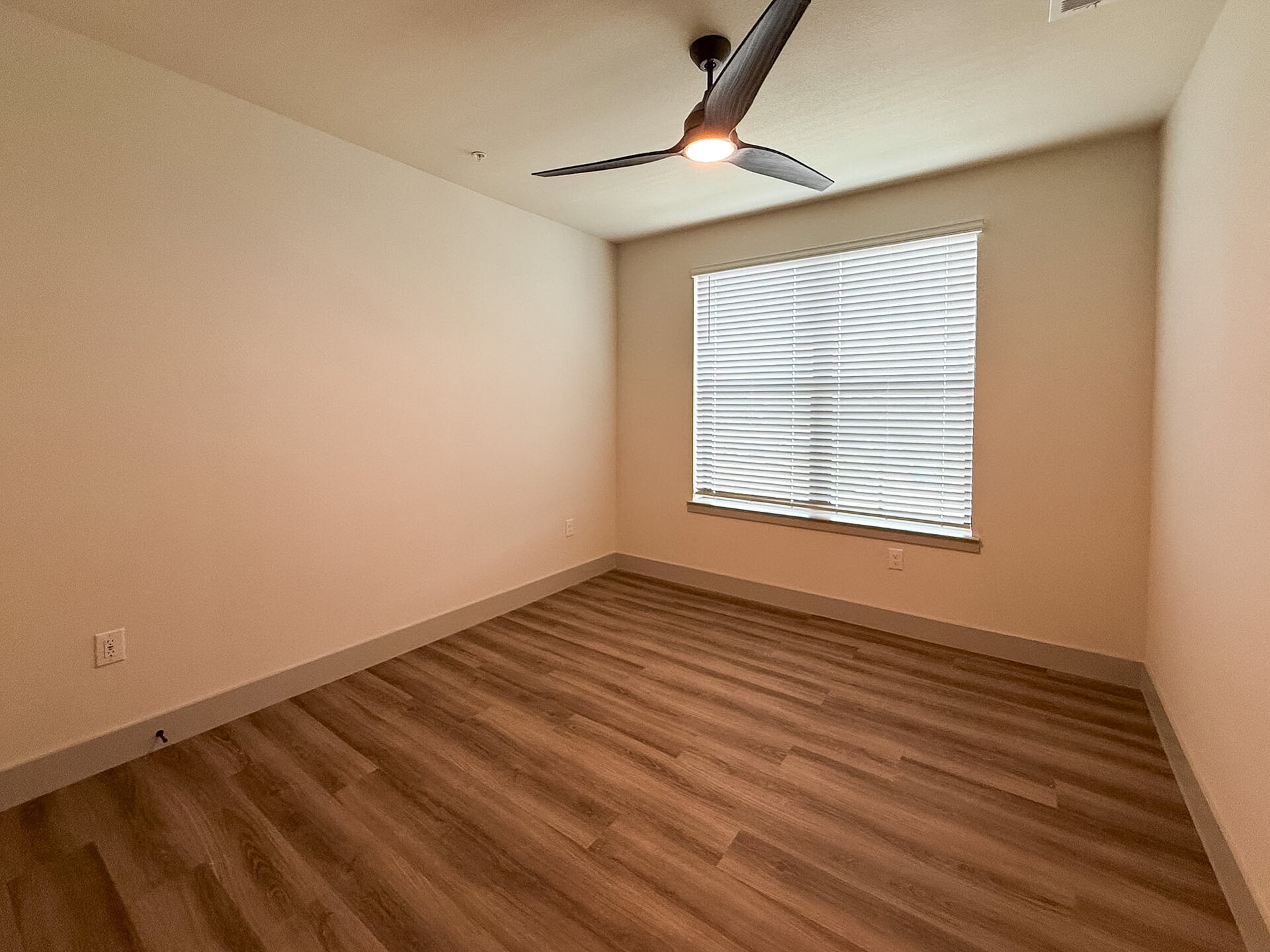 A San Antonio apartment spacious bedroom with a big window for plenty of natural sunlight to stream through & no carpet.