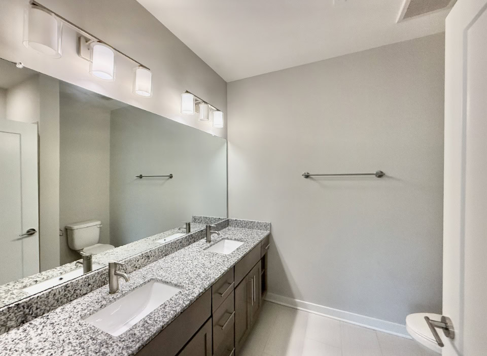 Nashville Apartment bathroom with a double vanity and brown wood cabinets.