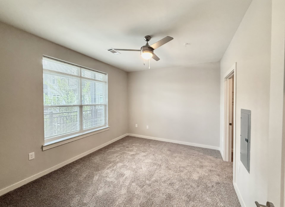 Nashville Apartment bedroom with large windows and carpeted floors.