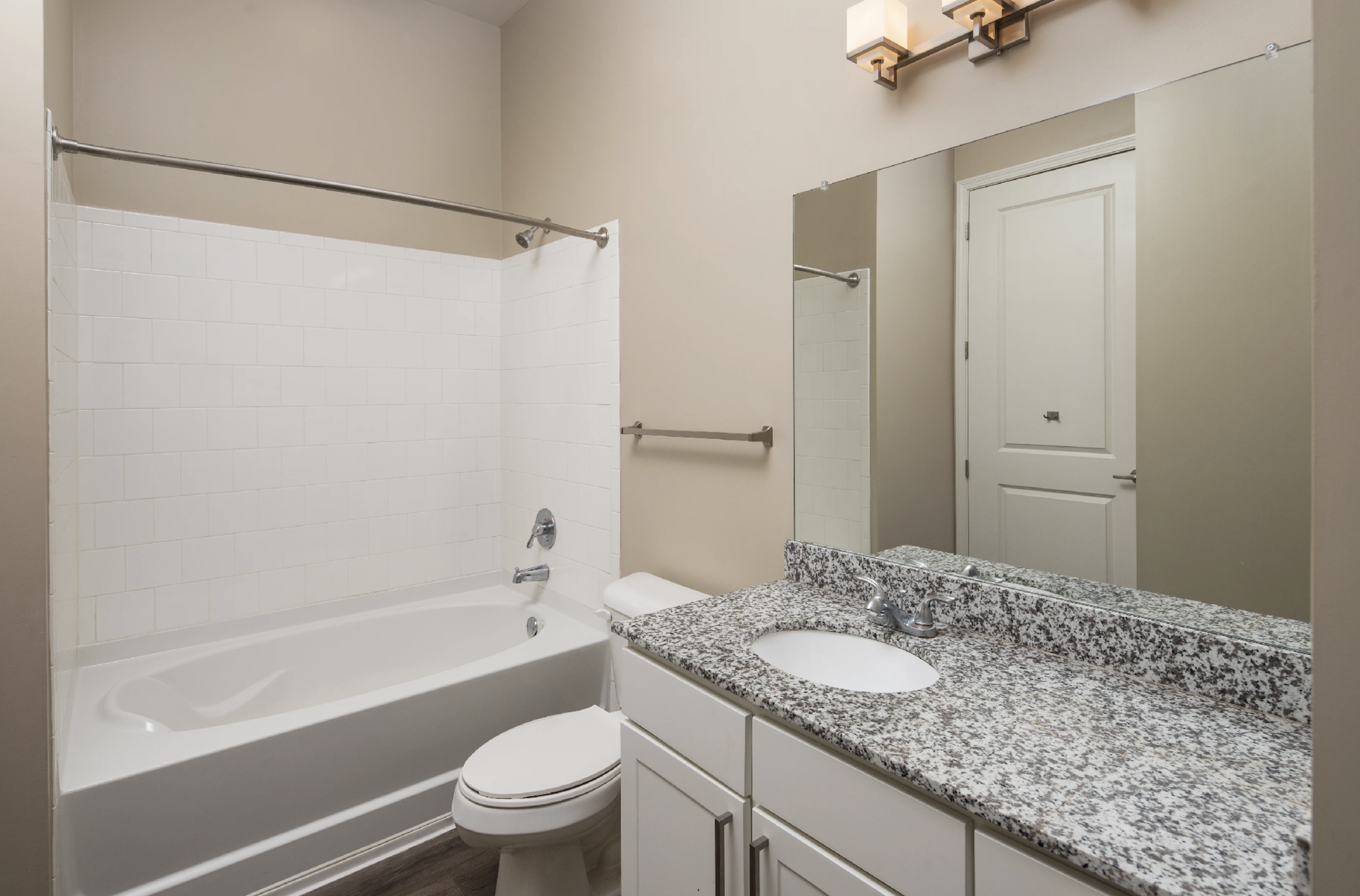 Atlanta Apartment bathroom with a bath tub and white cabinets.