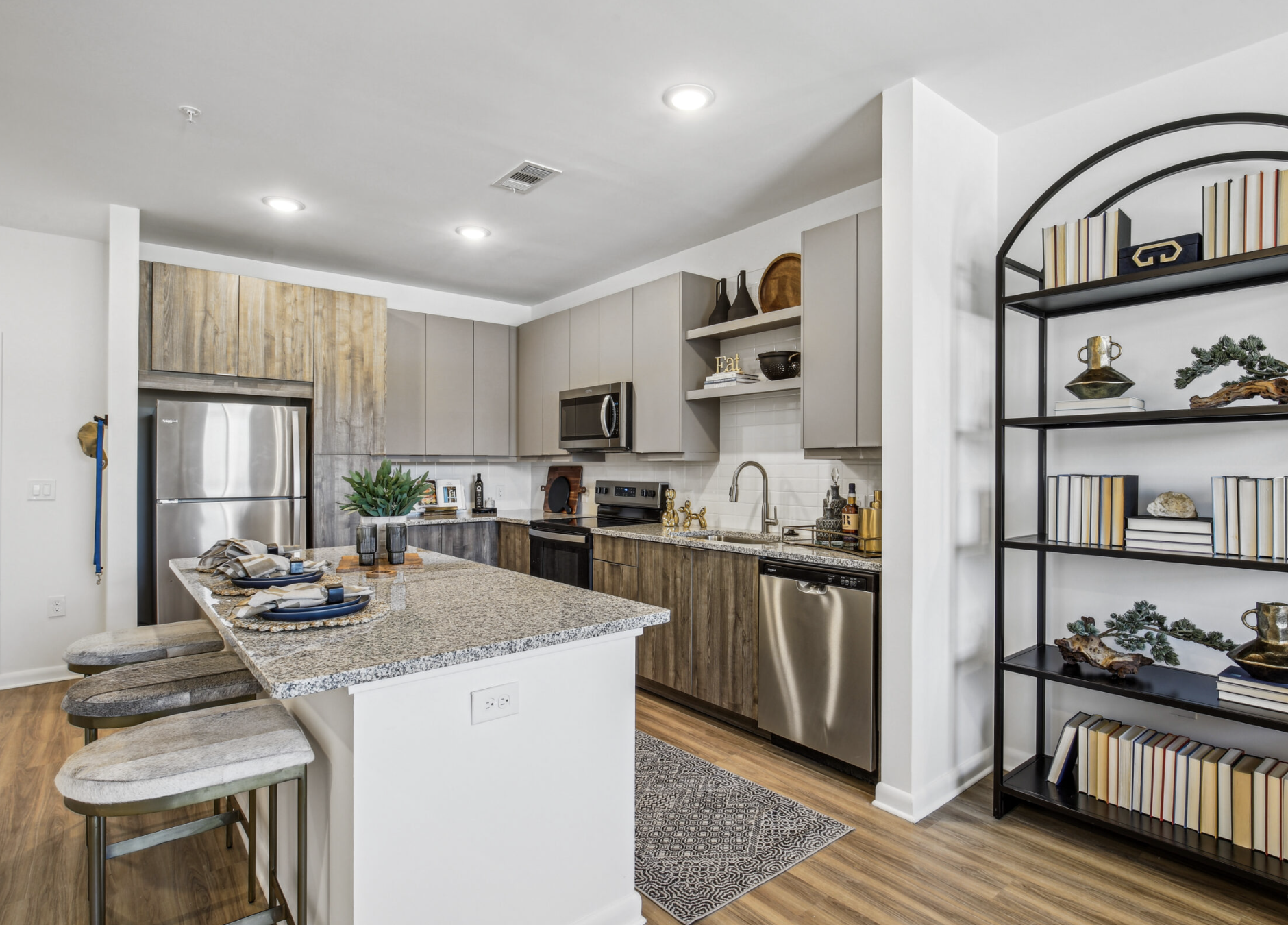 Atlanta Apartment kitchen with two tones cabinets, a large island, and stainless steel appliances.