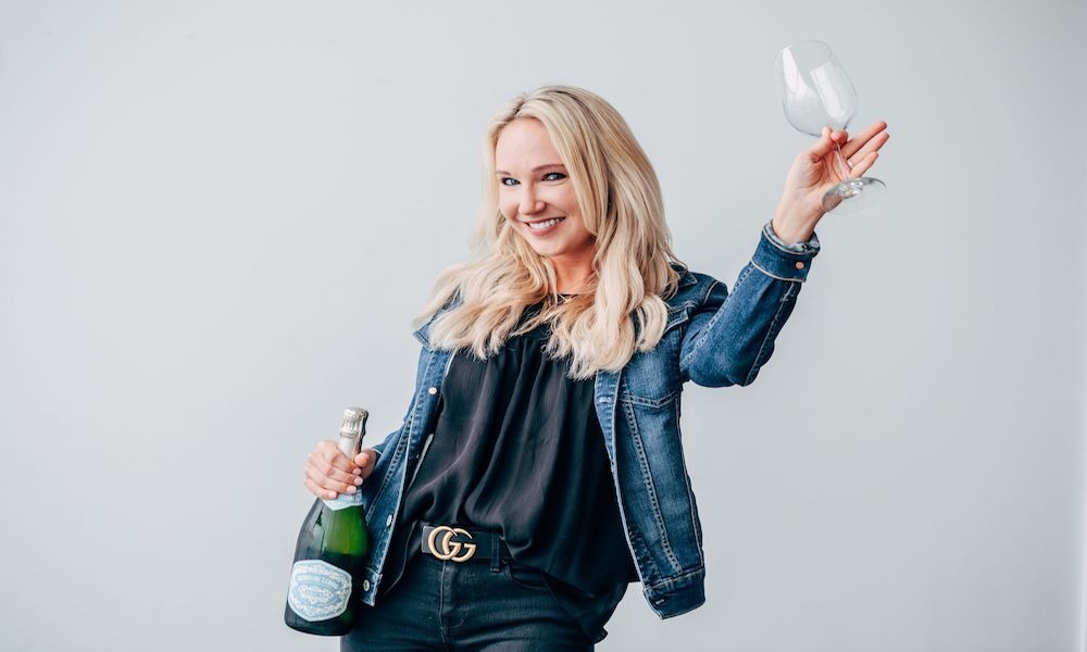girl holding wine glasses and bottle of wine